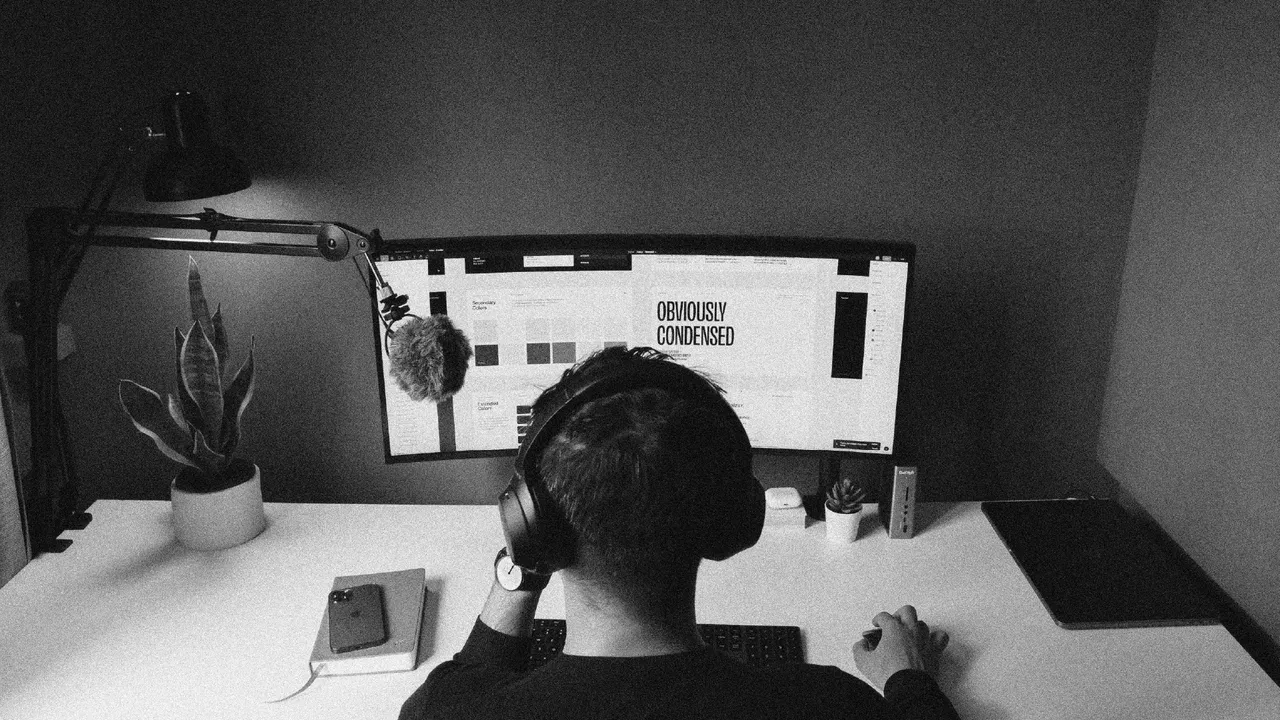 De costas, diante de uma tela com um estudo de marca aberto — o trabalho continua depois da entrega, na rotina da VØYD Estúdio.